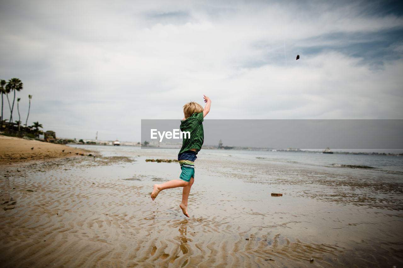 Six year old boy skipping rocks in coronado bay