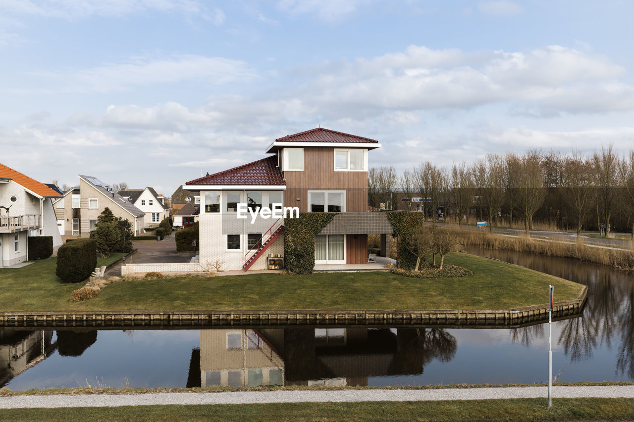 HOUSE BY LAKE AGAINST SKY