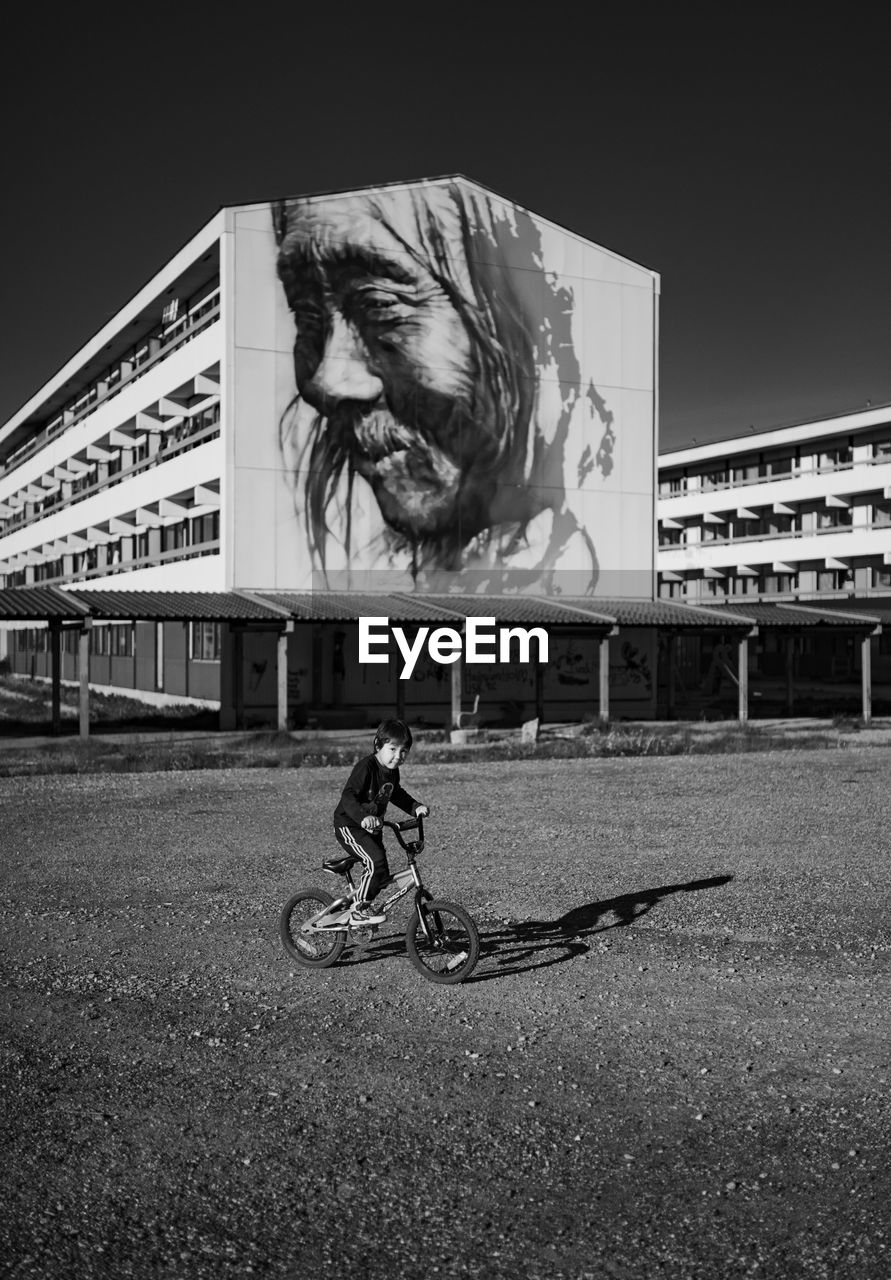 MAN RIDING BICYCLE ON CITY