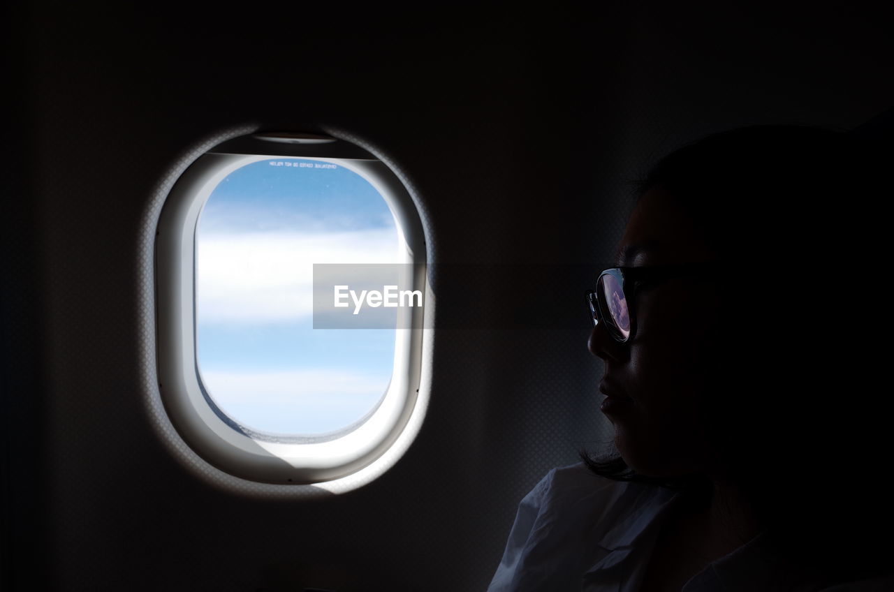 Close-up of woman by airplane window