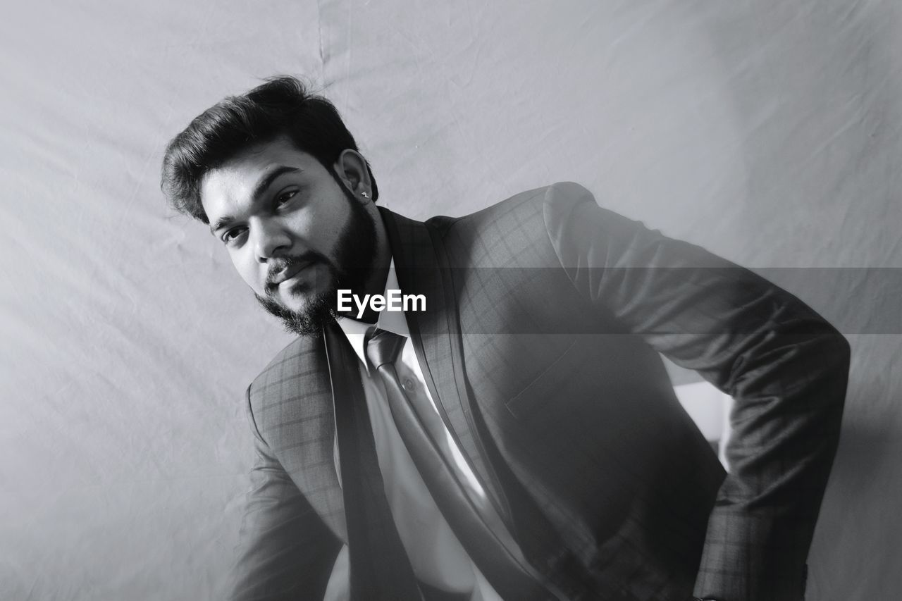 Handsome businessman posing against backdrop in studio