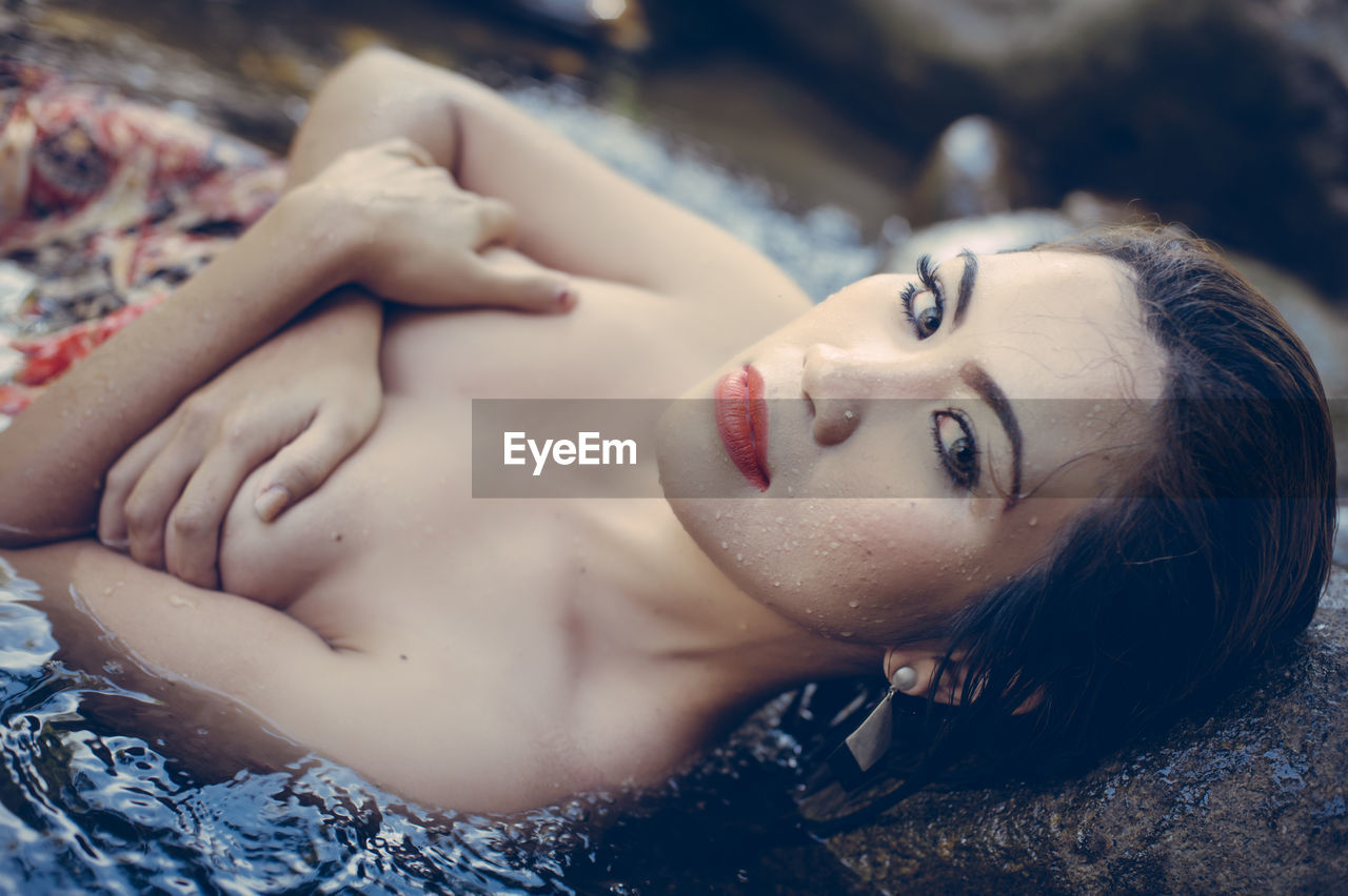 Close-up of beautiful woman lying in water