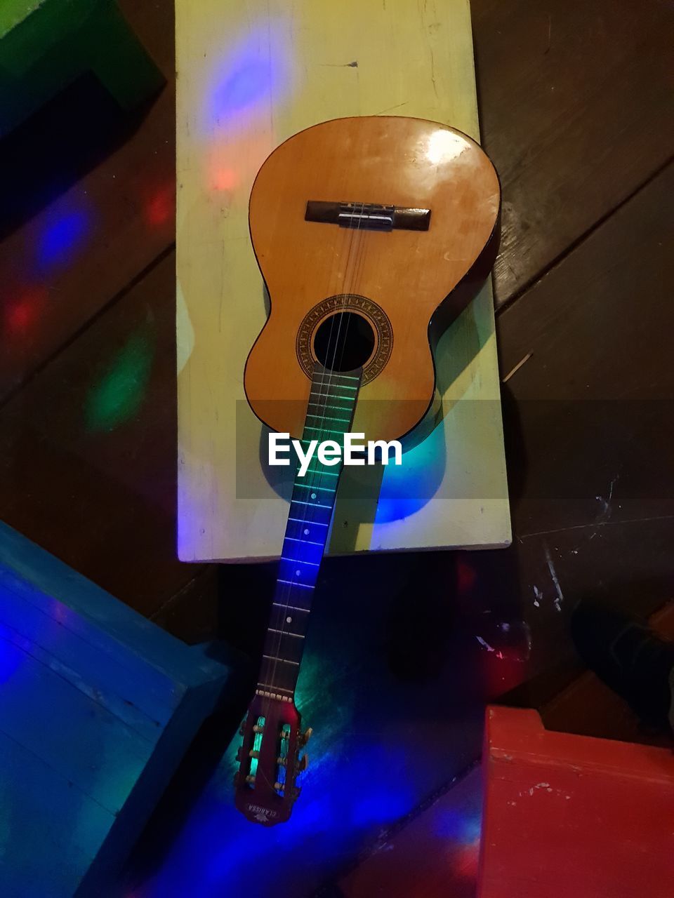 HIGH ANGLE VIEW OF GUITAR ON TABLE