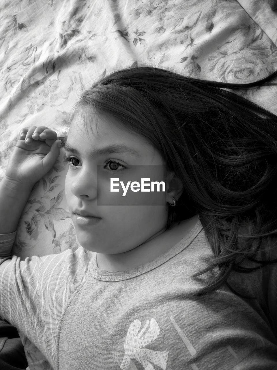 HIGH ANGLE PORTRAIT OF GIRL LYING DOWN ON BED