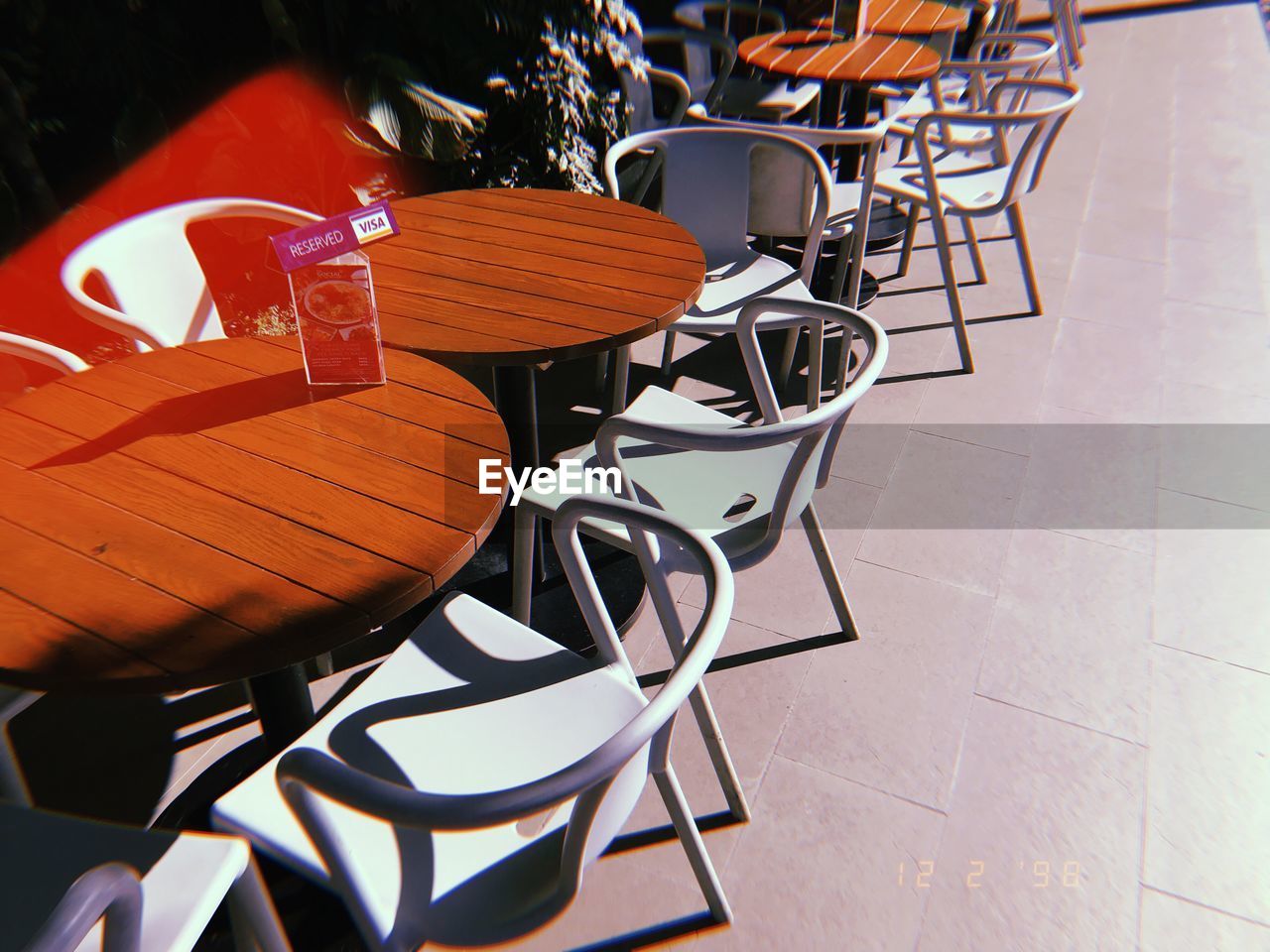 HIGH ANGLE VIEW OF CHAIRS AND TABLES AT SIDEWALK CAFE