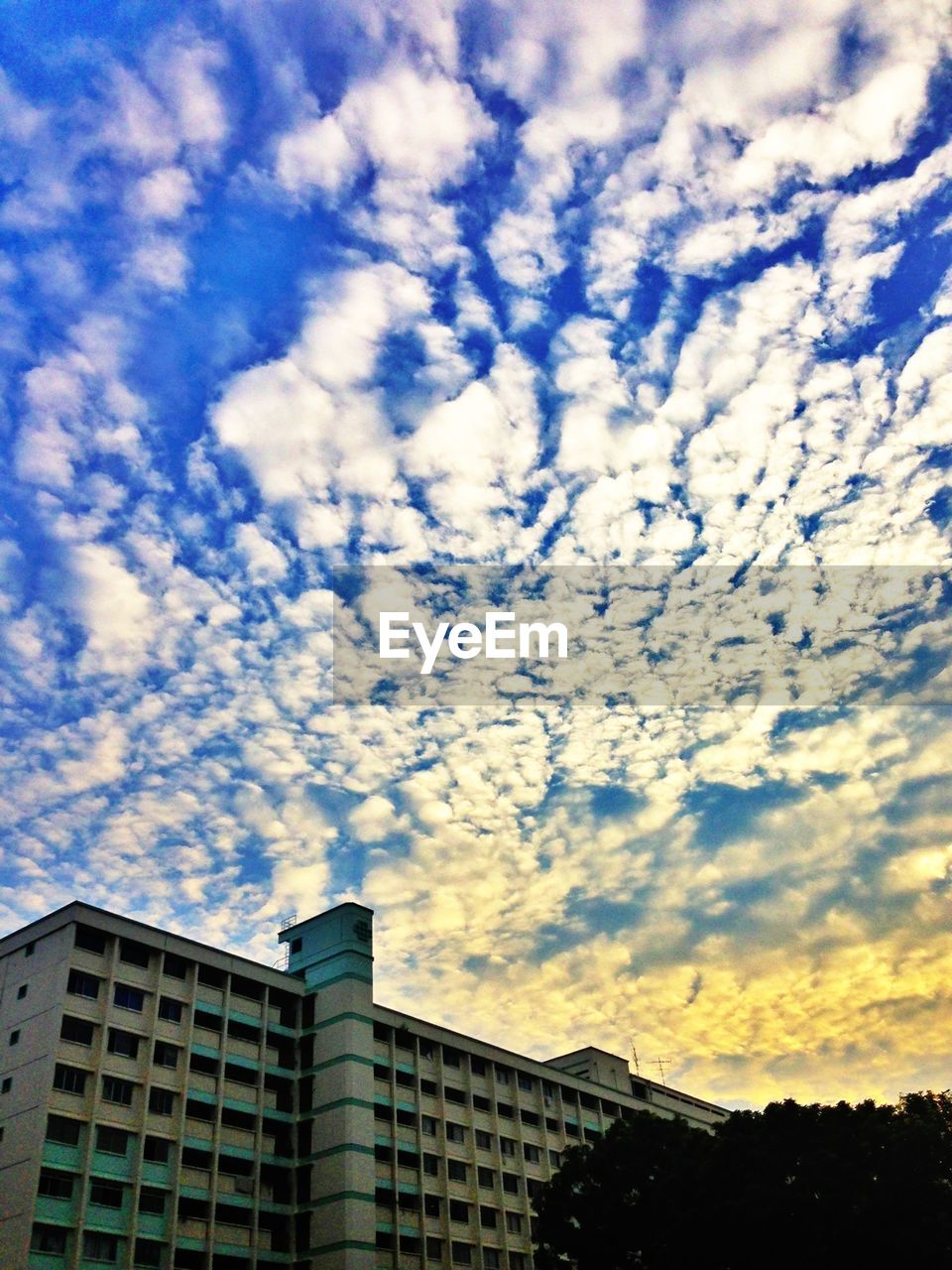 LOW ANGLE VIEW OF BUILDINGS AGAINST CLOUDY SKY