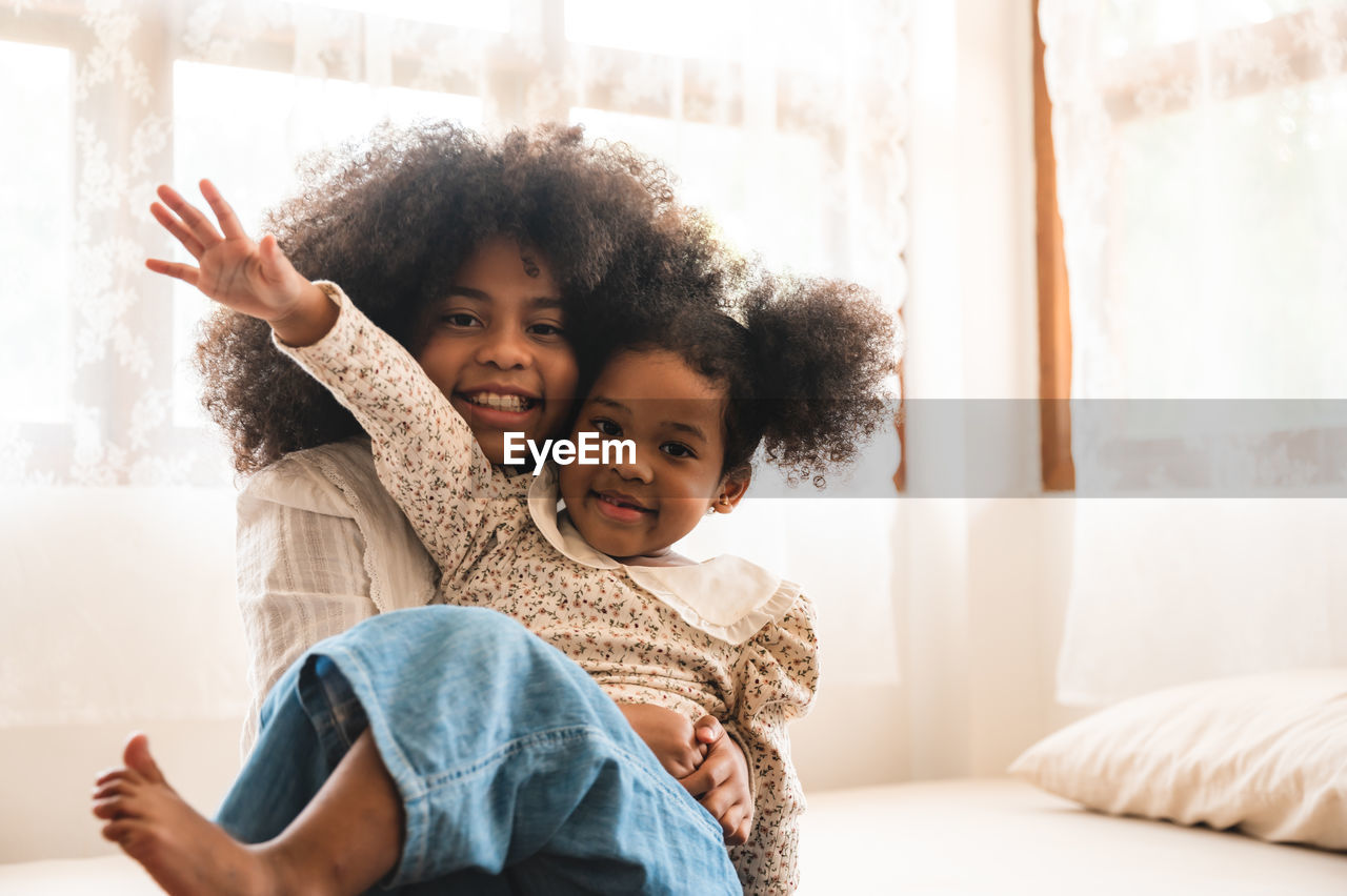 PORTRAIT OF HAPPY MOTHER AND DAUGHTER