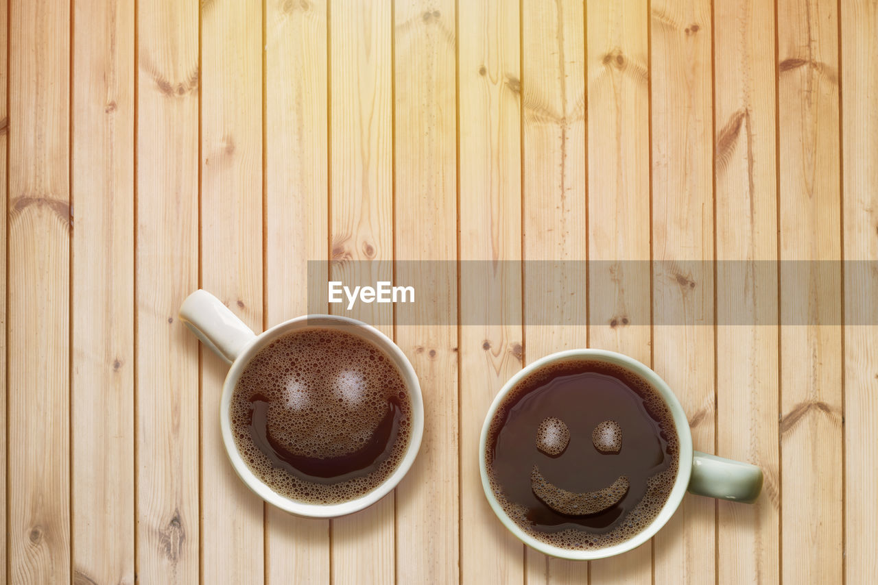 HIGH ANGLE VIEW OF COFFEE CUPS ON WOODEN TABLE