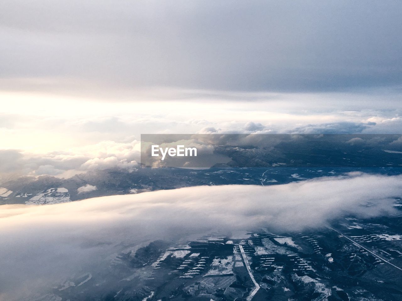 Aerial view of snow covered landscape against sky