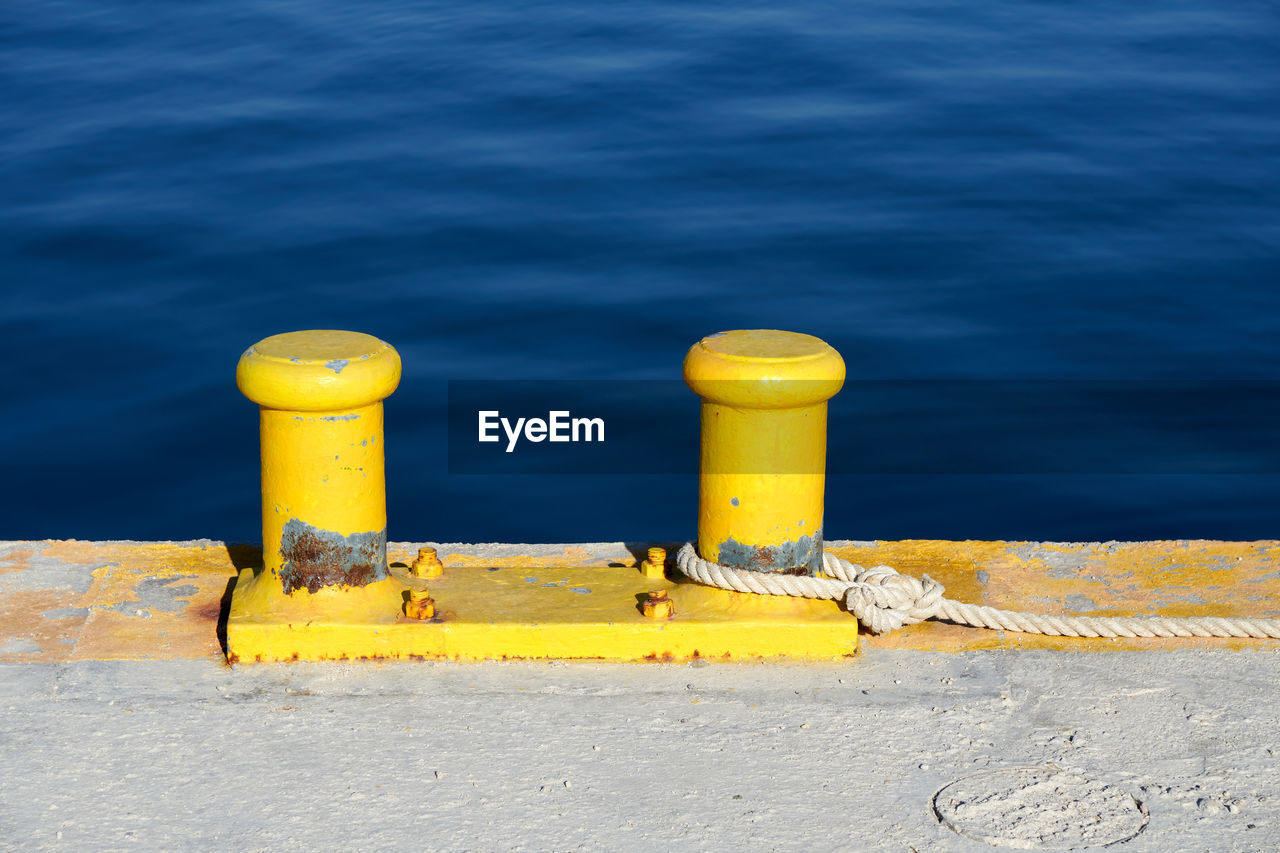 HIGH ANGLE VIEW OF YELLOW PIPE ON SEA