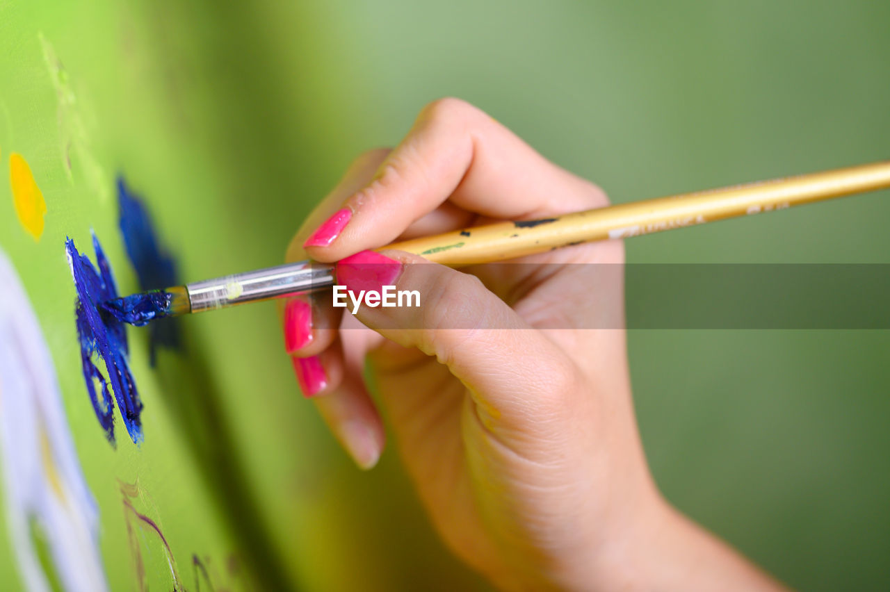 CLOSE-UP OF WOMAN HAND HOLDING BIRD