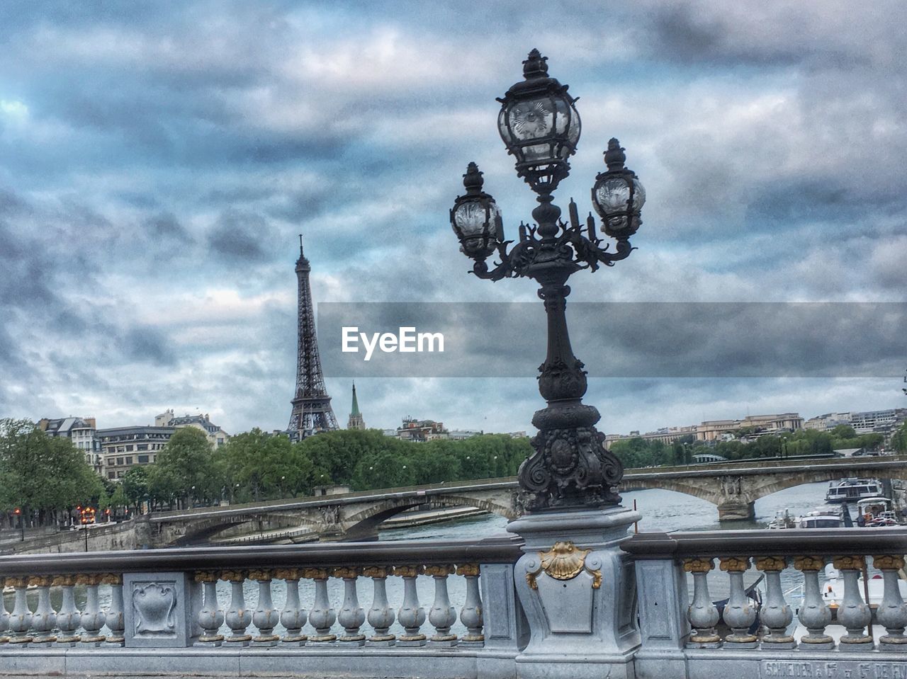 VIEW OF BRIDGE AND BUILDINGS AGAINST CLOUDY SKY