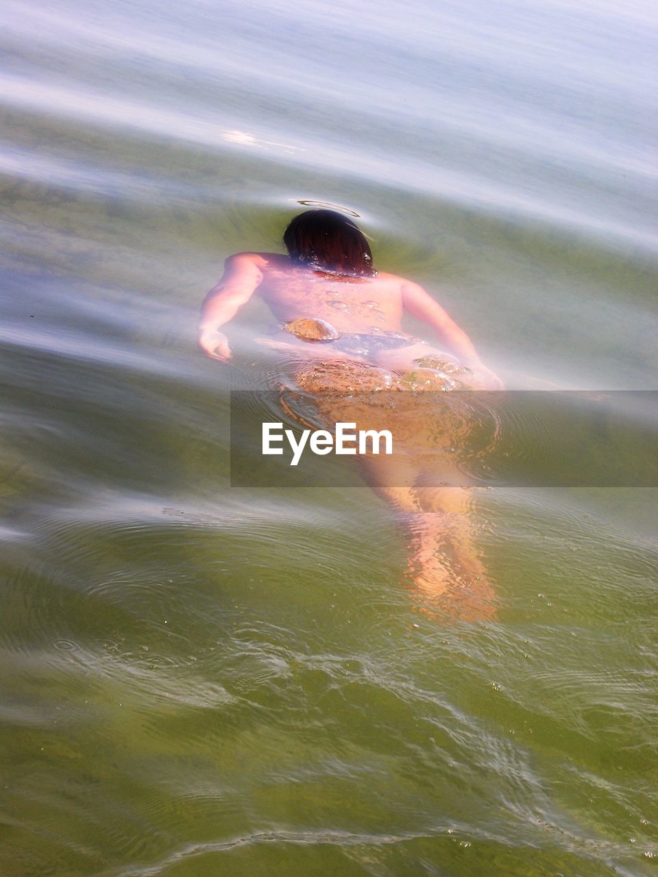 High angle view of young woman swimming in river