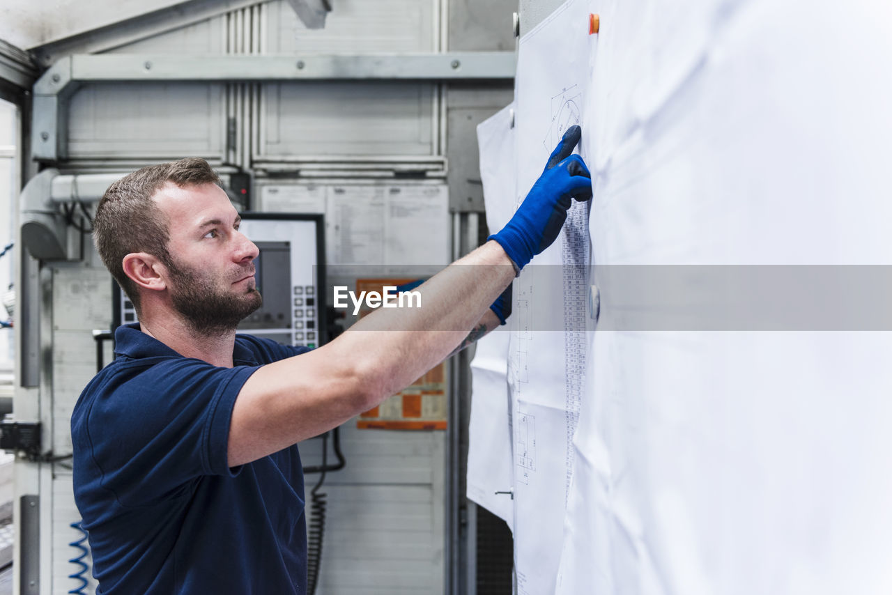 Man looking at plan in industrial factory