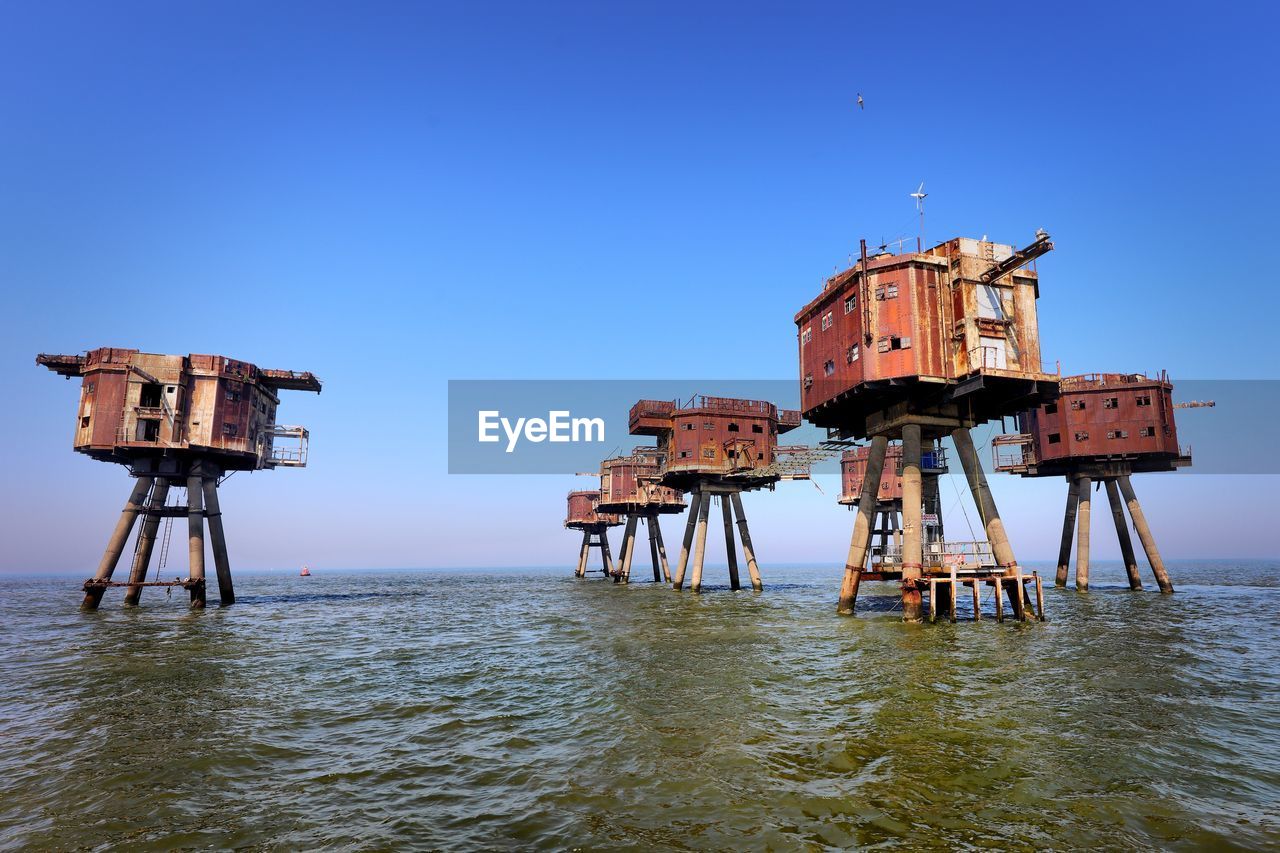 LIFEGUARD HUT IN SEA AGAINST CLEAR SKY