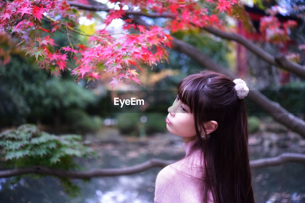 Portrait of woman looking at tree