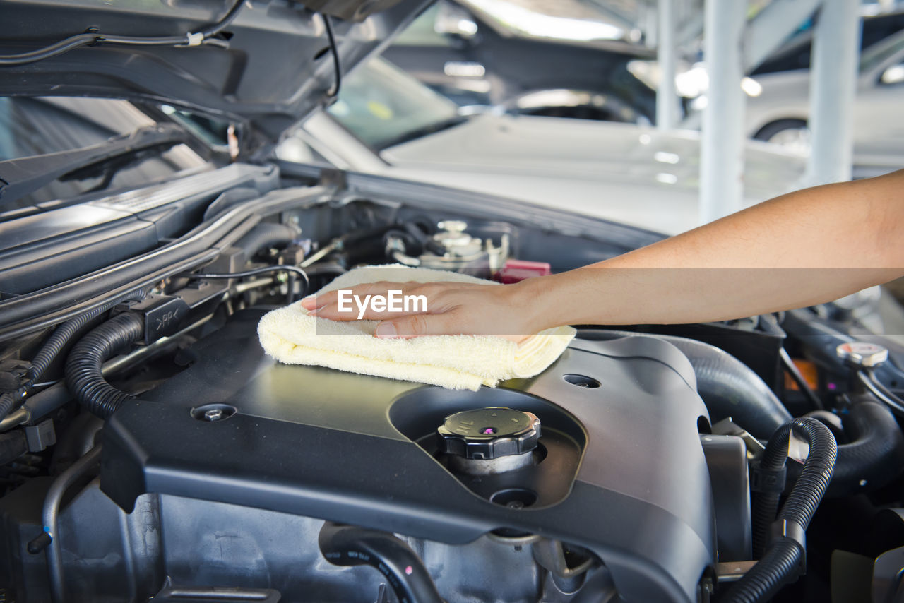 Hand cleaning car engine with a rag,worker
