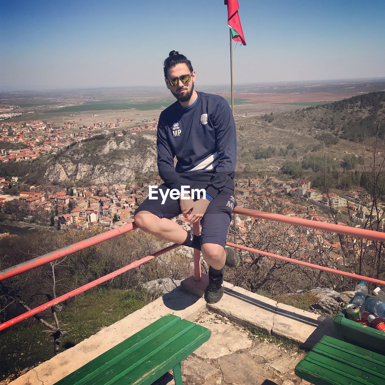 Full length of man sitting on railing against sky