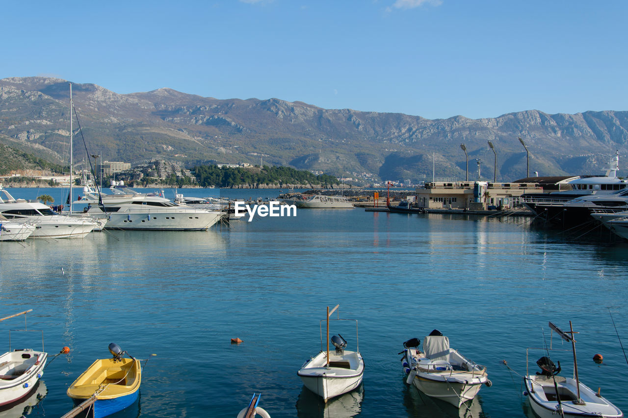 BOATS MOORED ON SEA AGAINST SKY