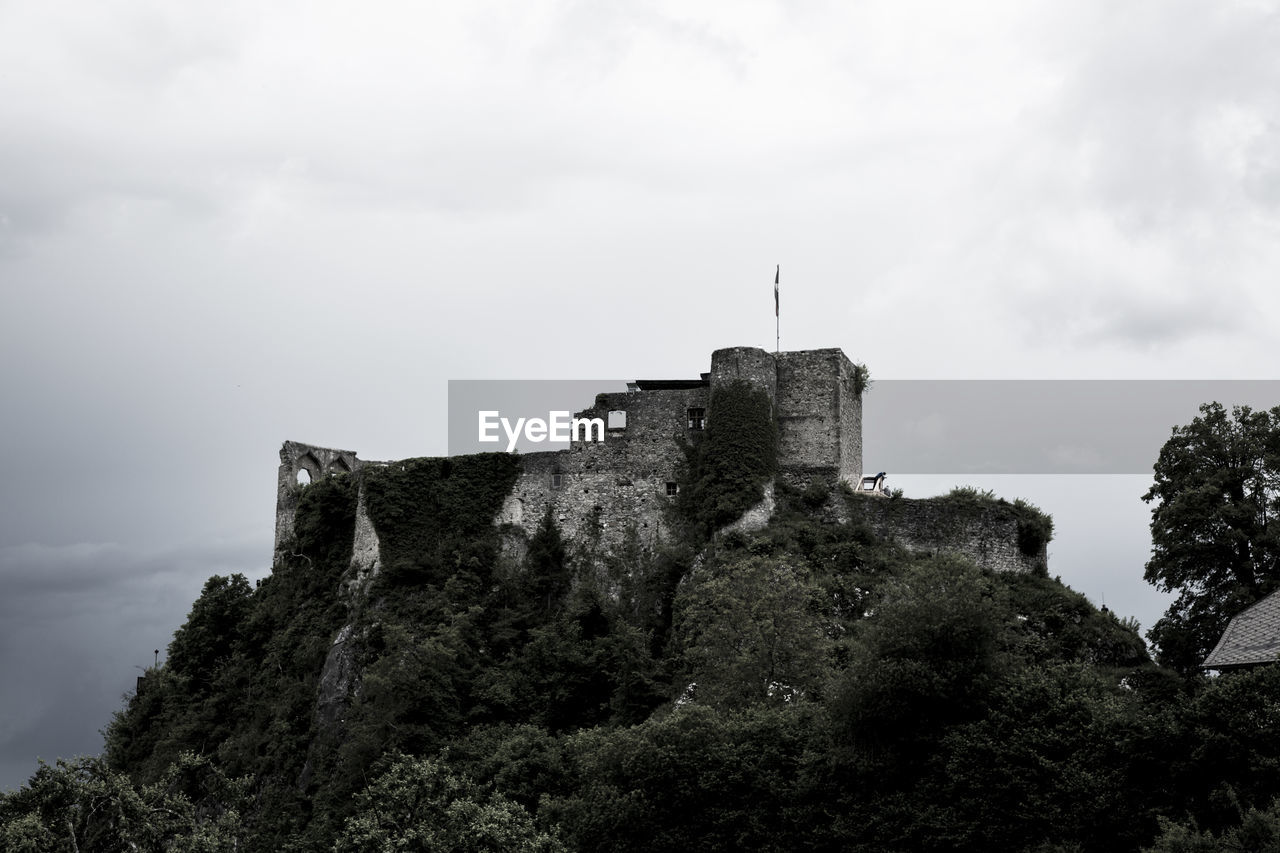 Low angle view of castle on hill against cloudy sky