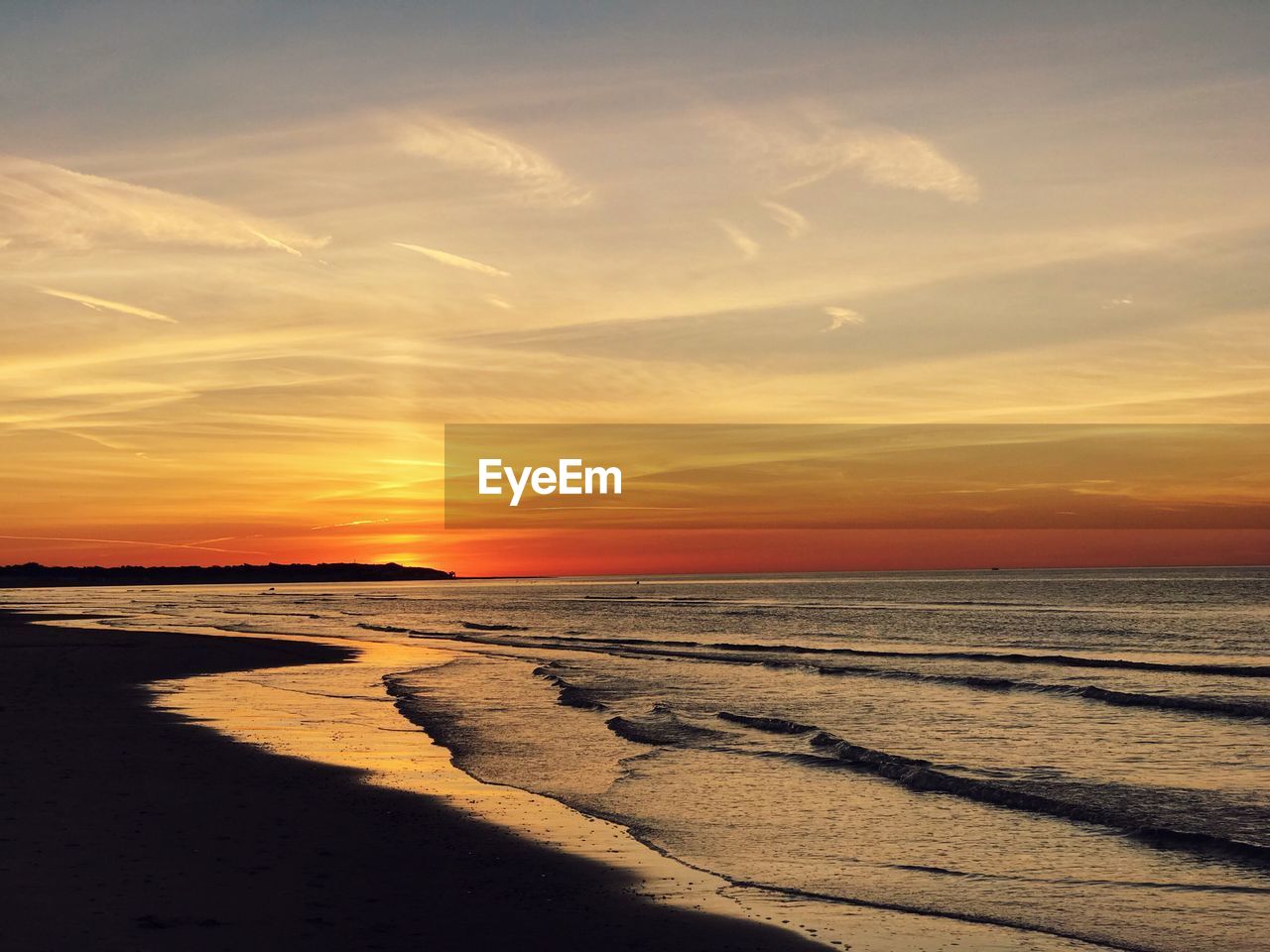 Scenic view of beach against sky during sunset