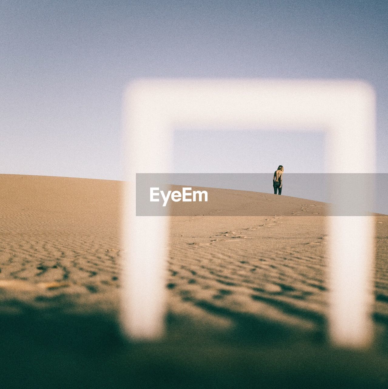 Person walking at desert against sky