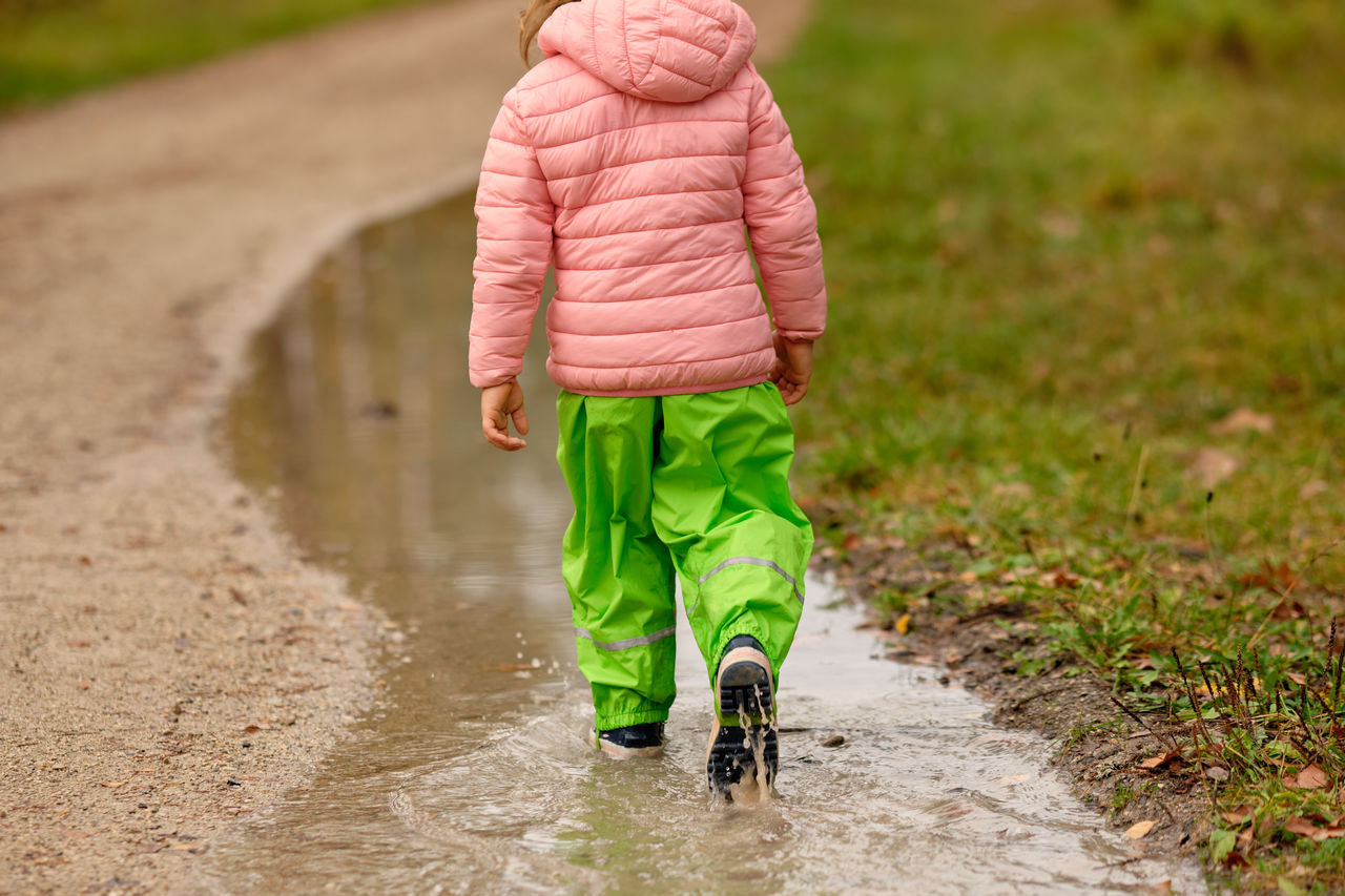 Low section of woman standing on wet road