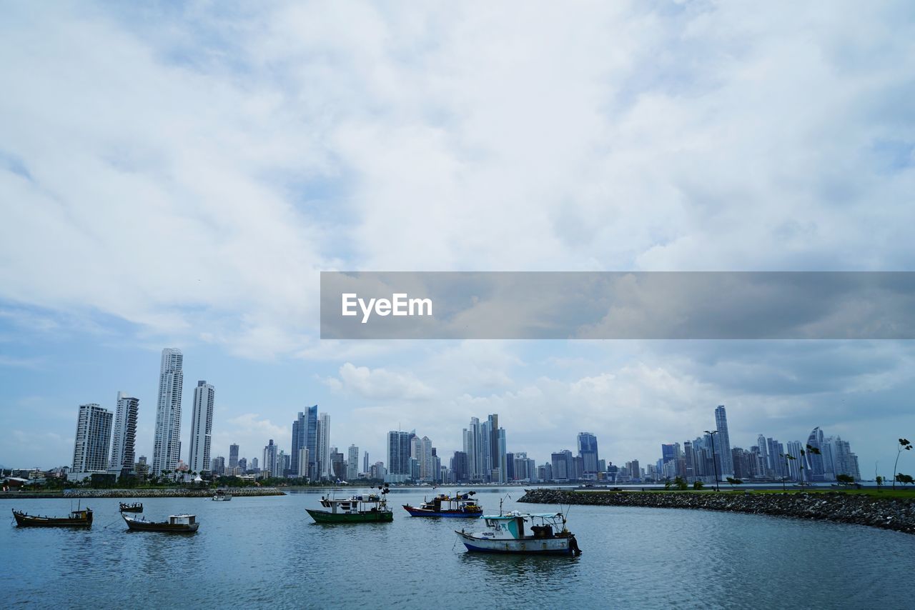 Boat in river with city in background