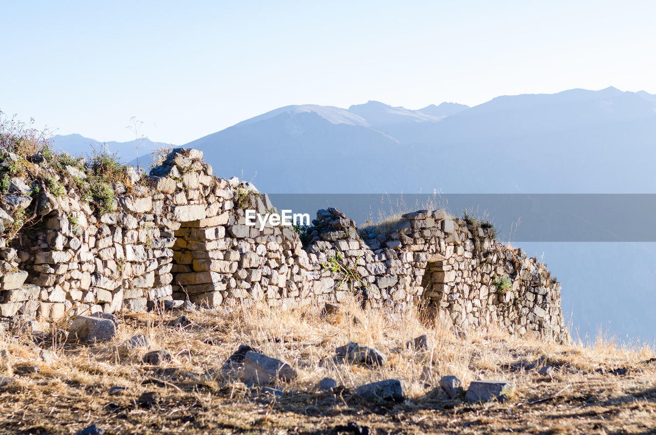 RUINS OF BUILDING AGAINST MOUNTAIN