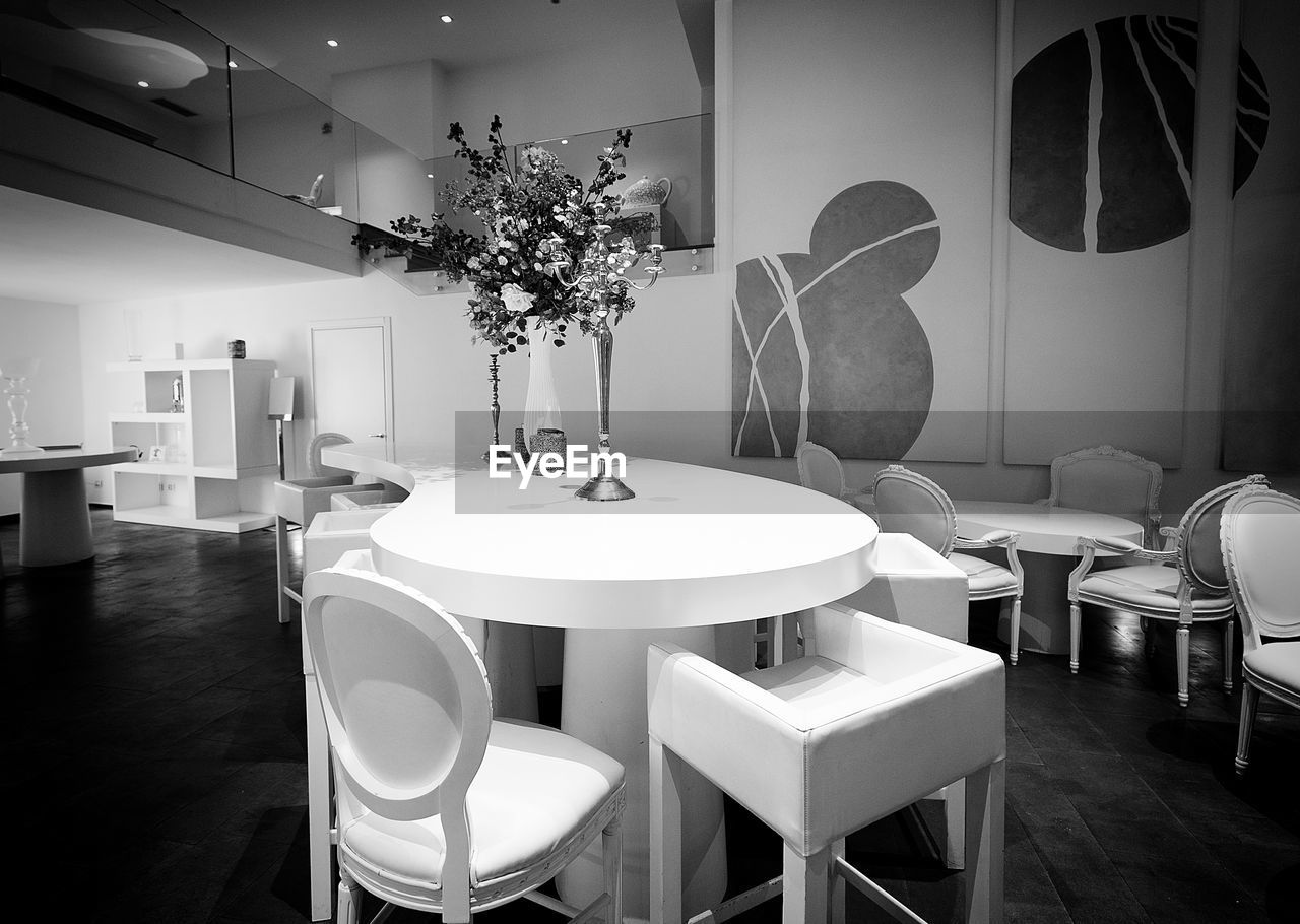 table, room, seat, furniture, chair, home interior, indoors, black and white, dining room, white, domestic room, home, elegance, luxury, interior design, wealth, monochrome, no people, lighting equipment, monochrome photography, architecture, home showcase interior, dining table, business, lighting, building, lifestyles, plant, built structure, domestic life