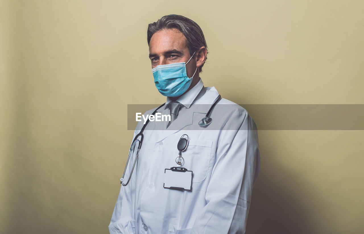 Doctor wearing mask against colored background