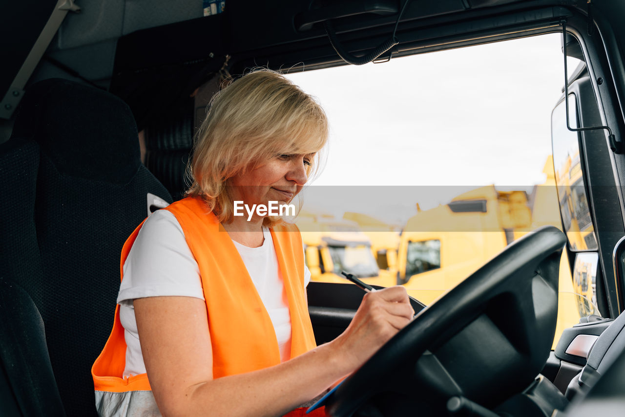 Portrait of young woman sitting in car