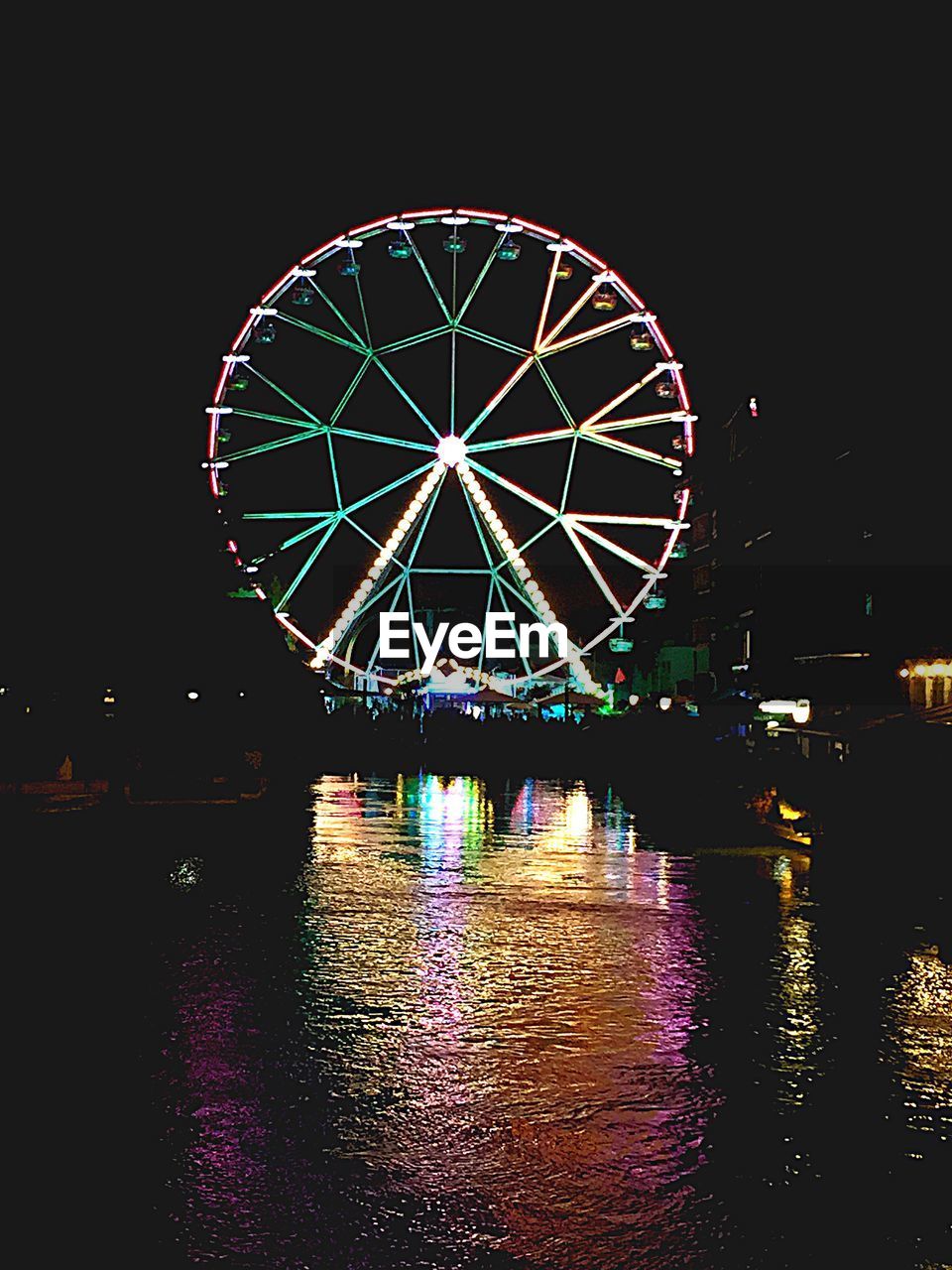 ILLUMINATED FERRIS WHEEL IN BACKGROUND