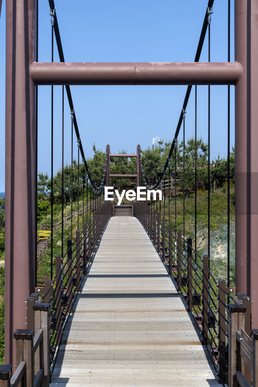 Empty footbridge against clear sky