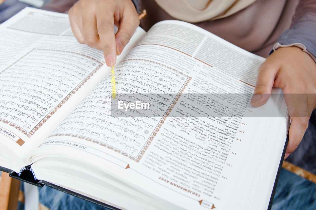 MIDSECTION OF PERSON READING BOOK