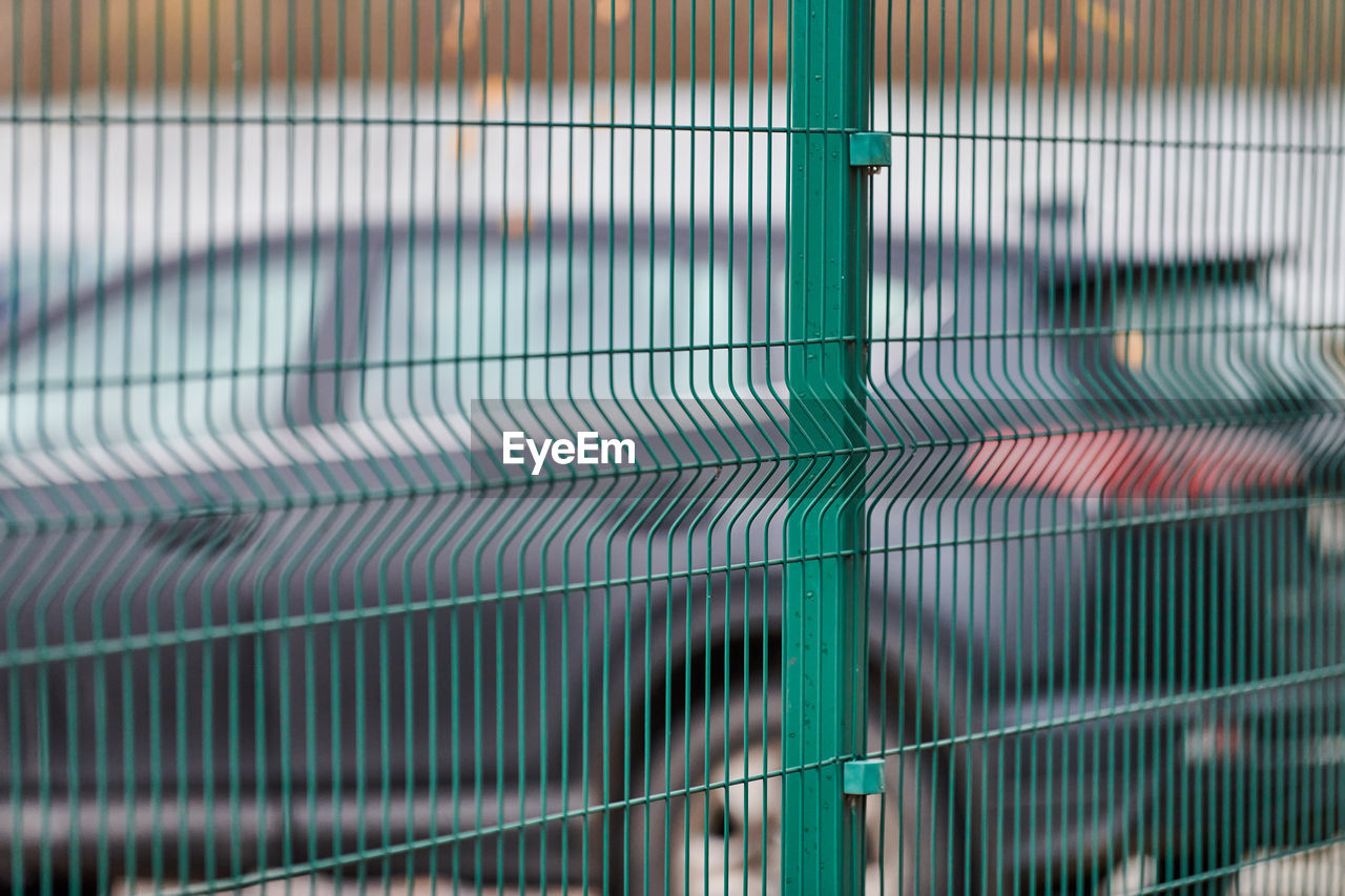 Fenced car parking lot with security. guarded territory of paid hourly parking. blurred car backdrop