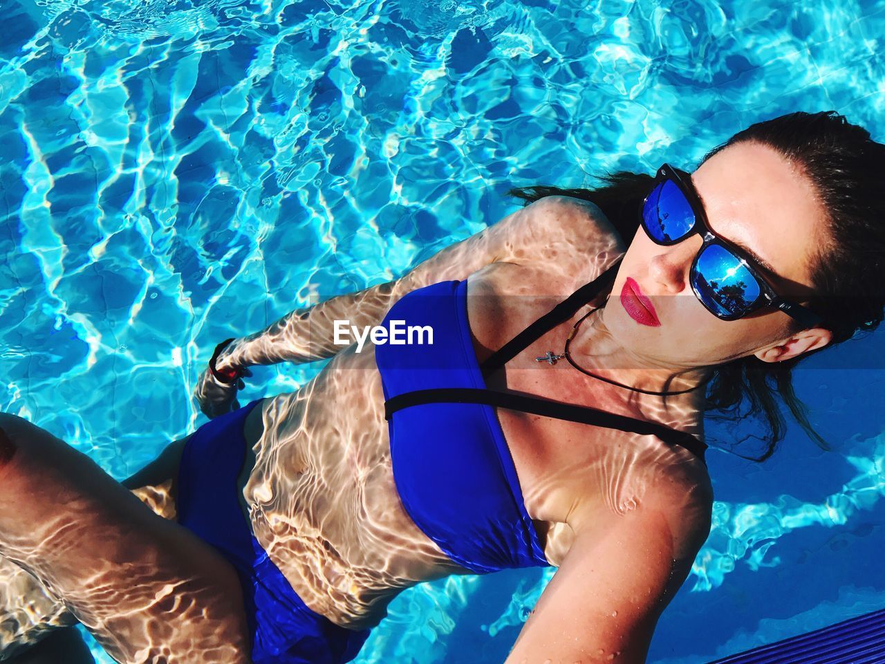 High angle view of sensuous woman wearing blue bikini in pool