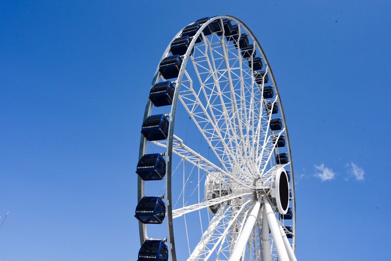 Low angle view of ferris wheel against blue sky