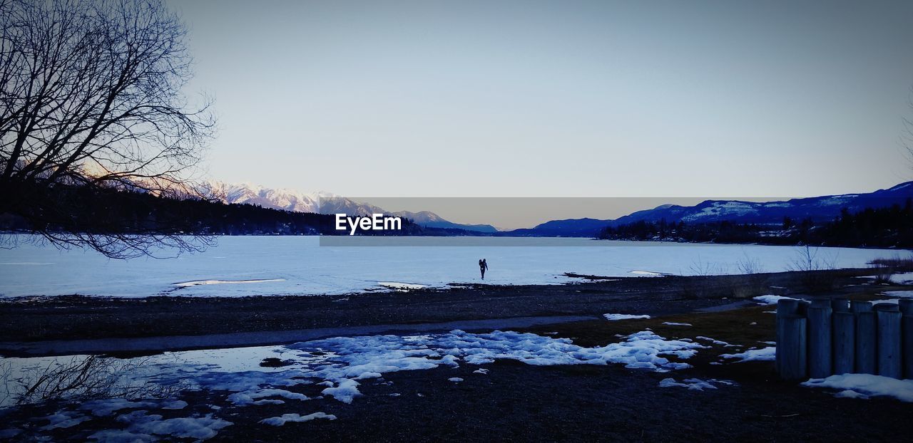 SCENIC VIEW OF FROZEN LAKE AGAINST CLEAR SKY