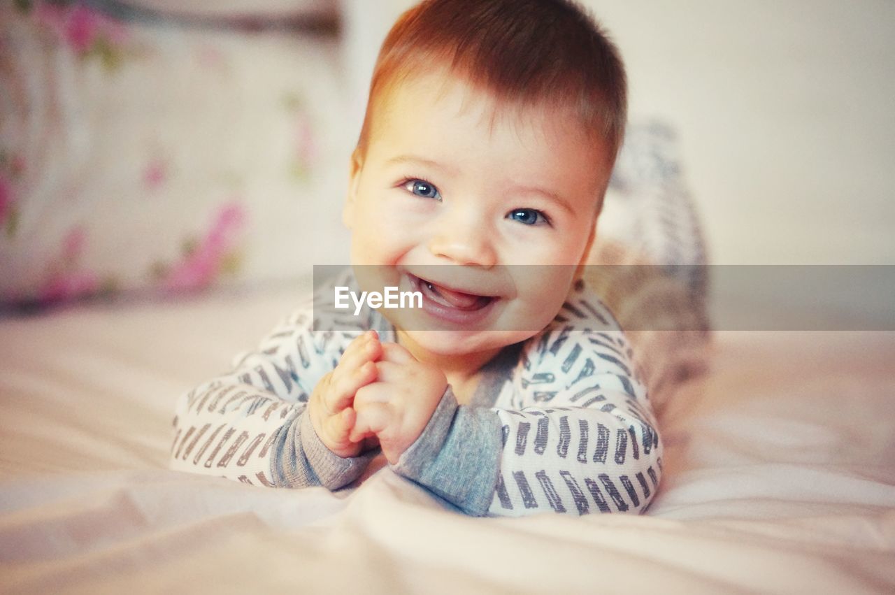 Portrait of cute baby laughing in bed at home