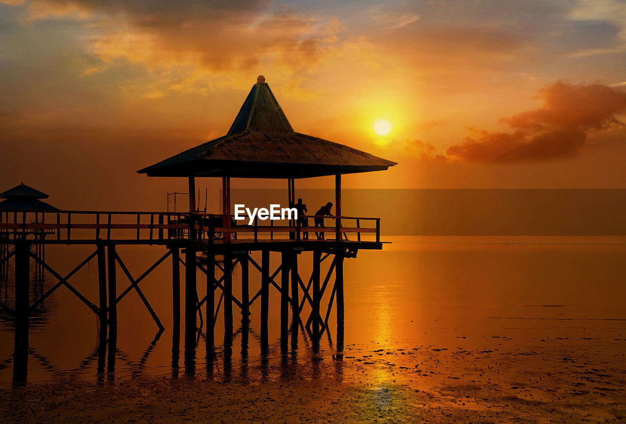 GAZEBO IN SEA DURING SUNSET