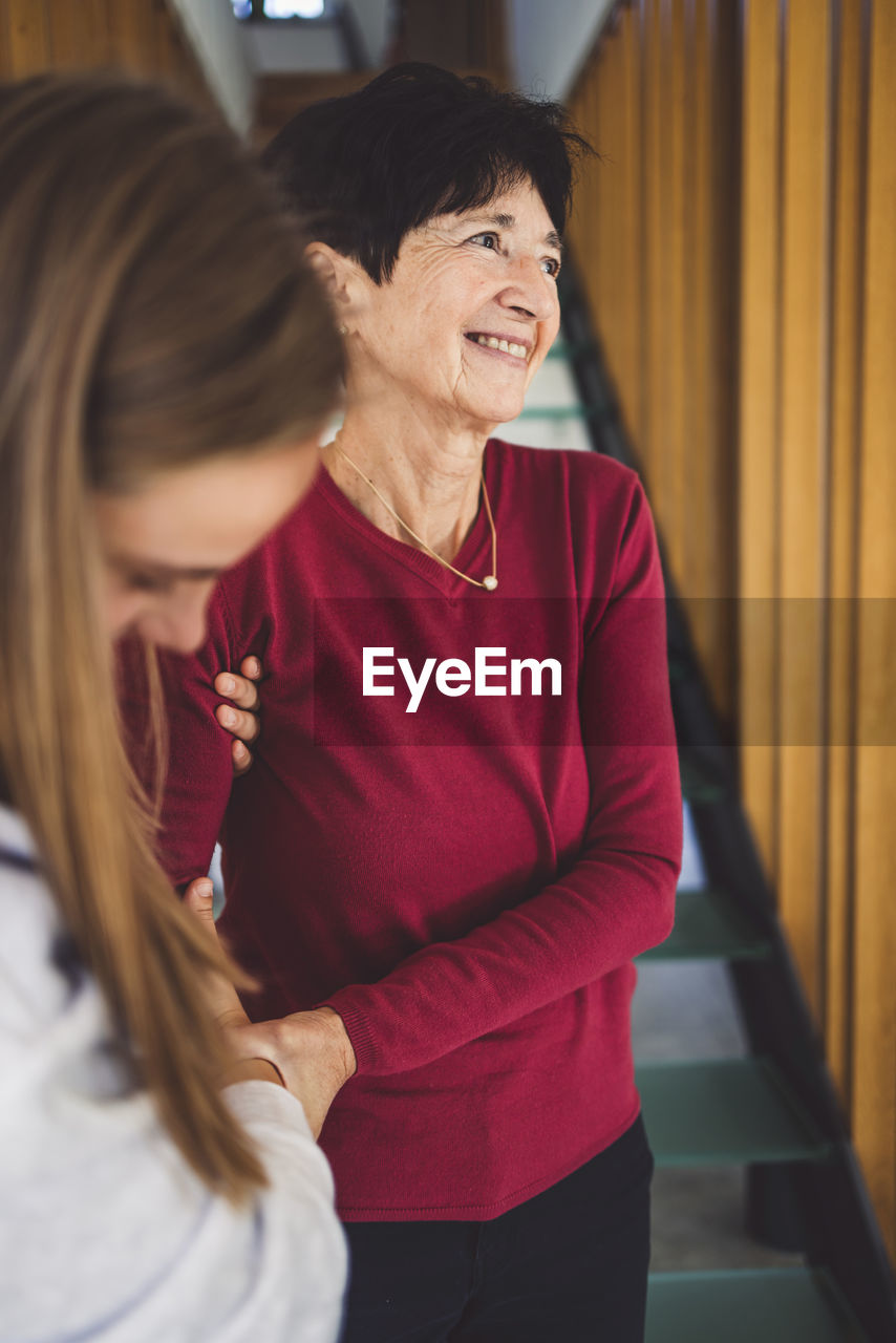 Smiling senior woman getting help from her nurse to live comfortably at home