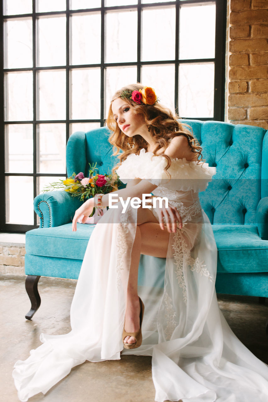 Redhead bride in dress holding wedding bouquet and smiling. wedding day concept