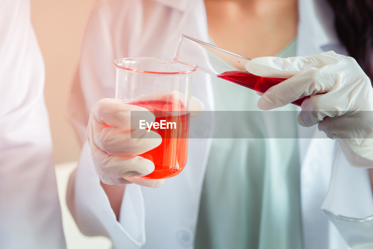 CLOSE-UP OF WOMAN HOLDING RED WINE GLASS