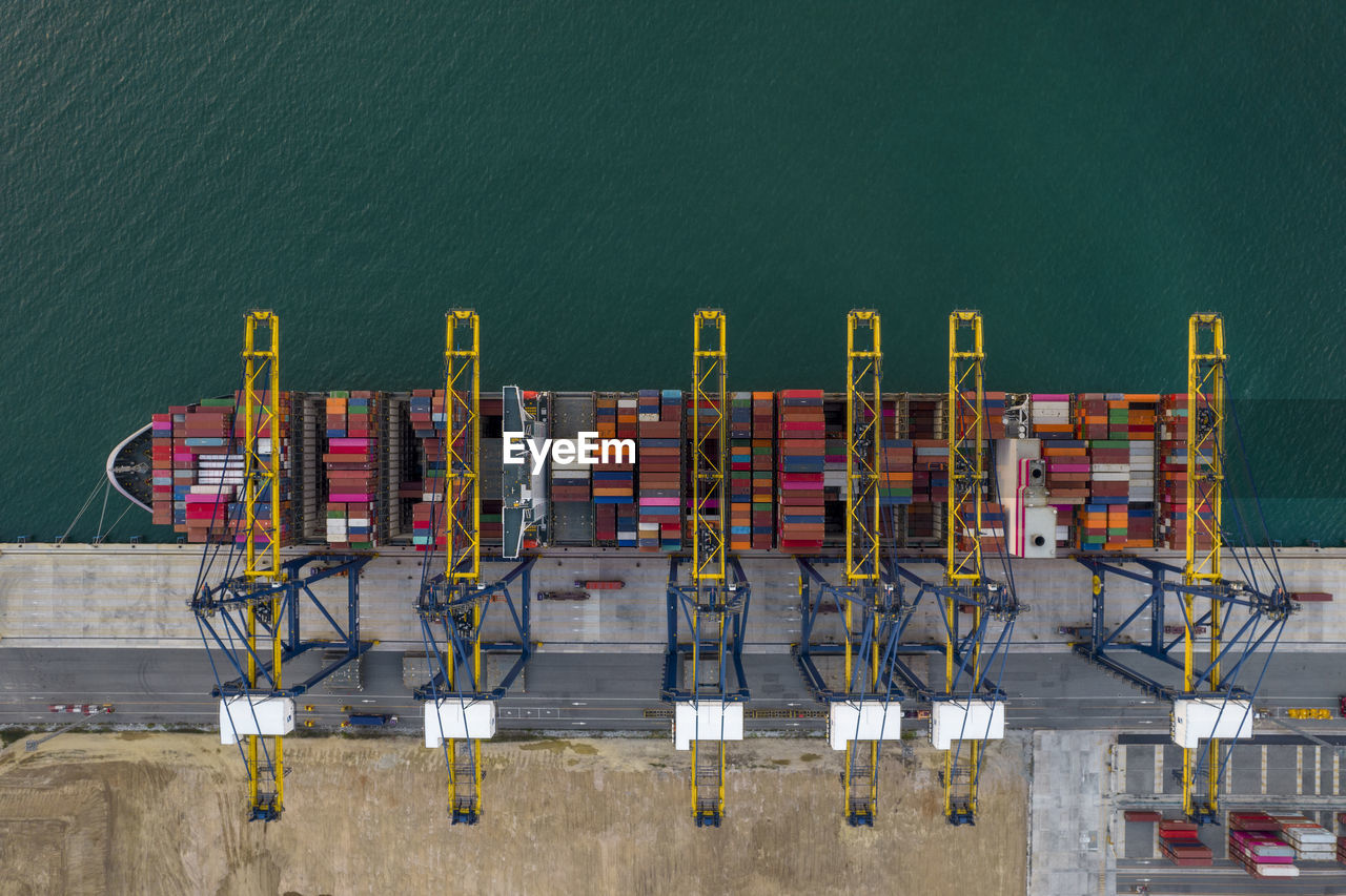 Aerial top view of crane loanding cargo container to container ship in the international terminal