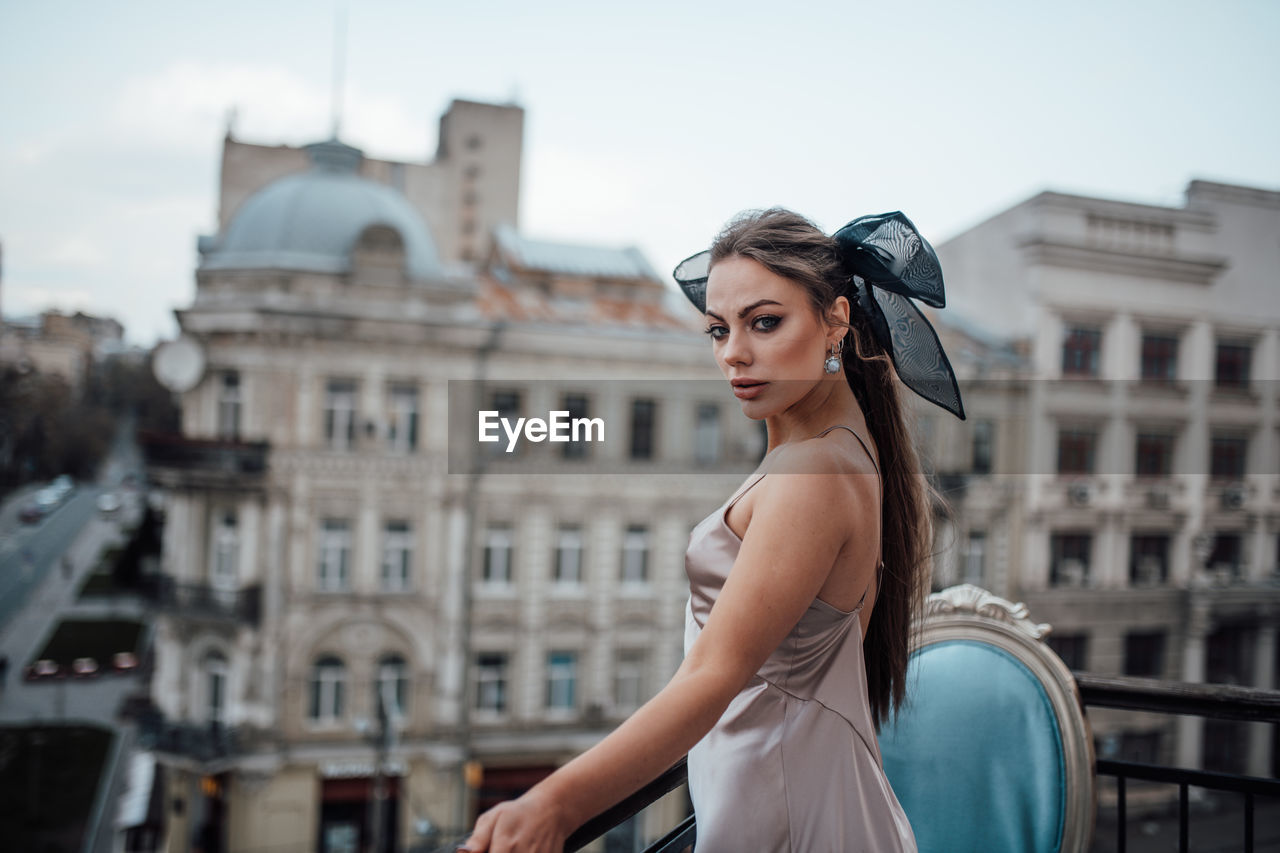 Happy woman standing against buildings in city