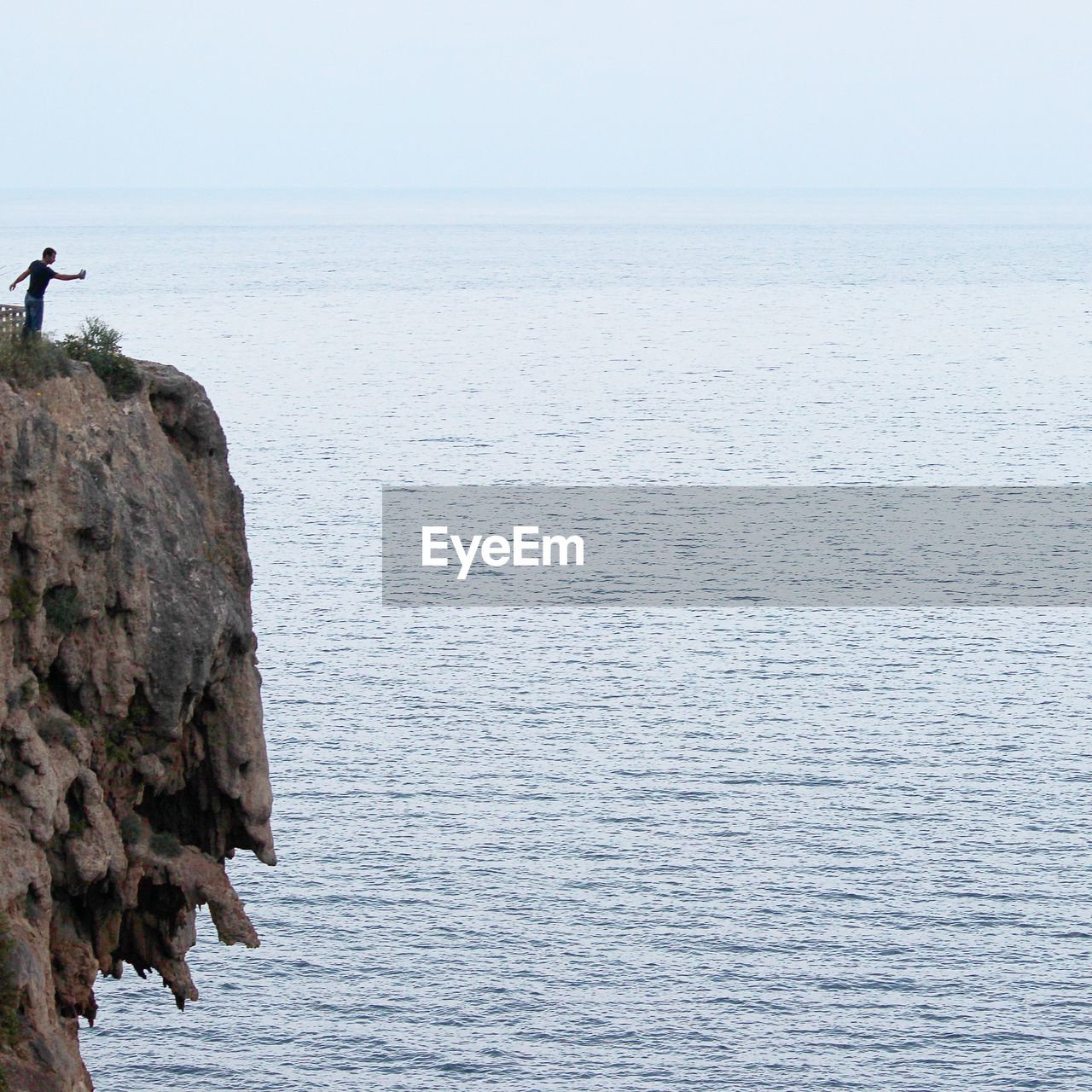 Man standing on cliff against sea