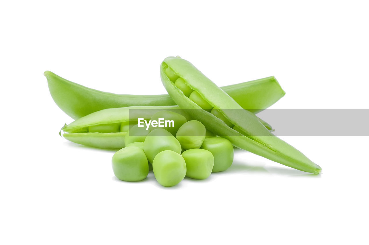 Close-up of peas and pea pods on white background