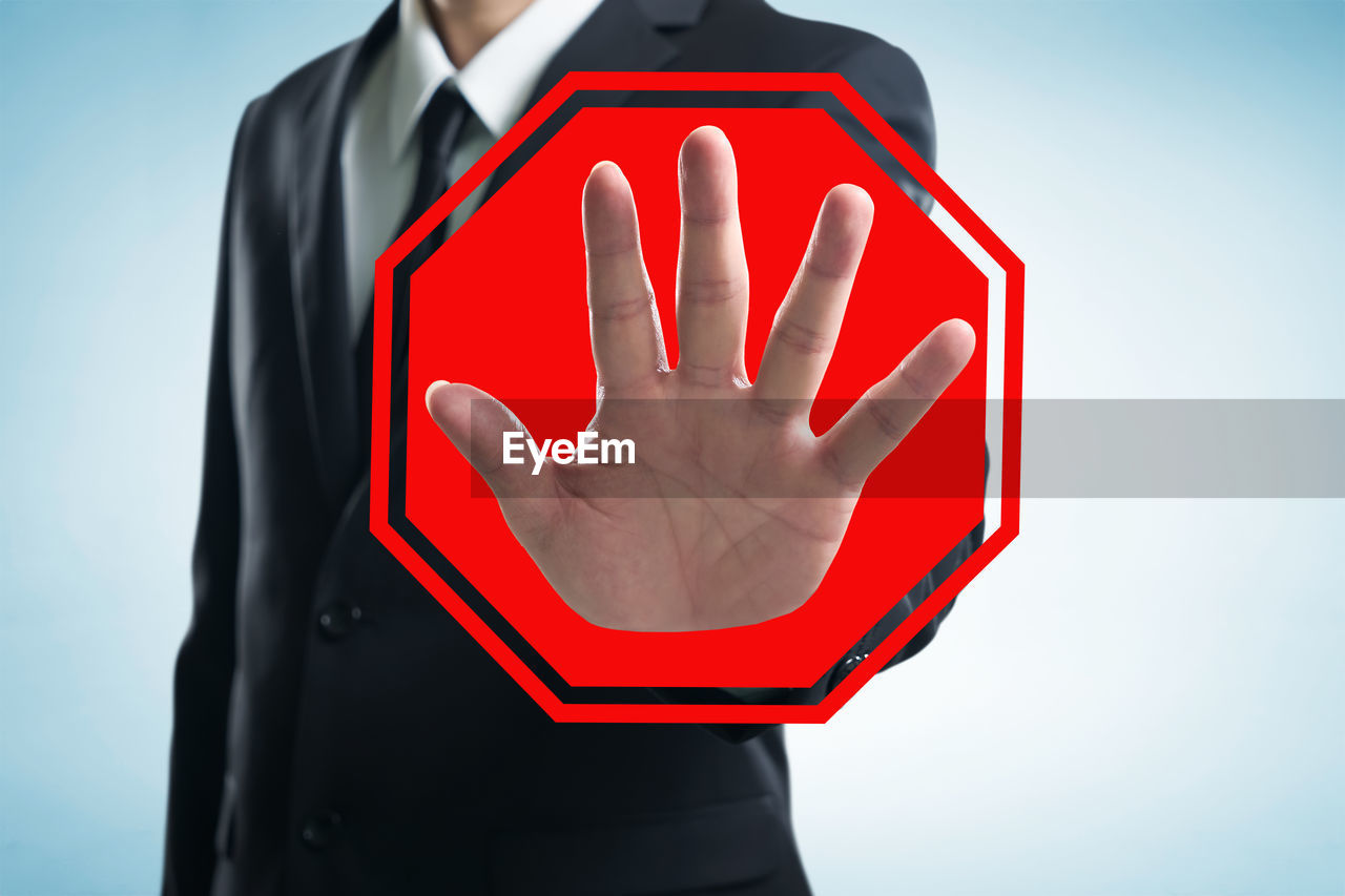 CLOSE-UP OF A RED HAND AGAINST WHITE BACKGROUND