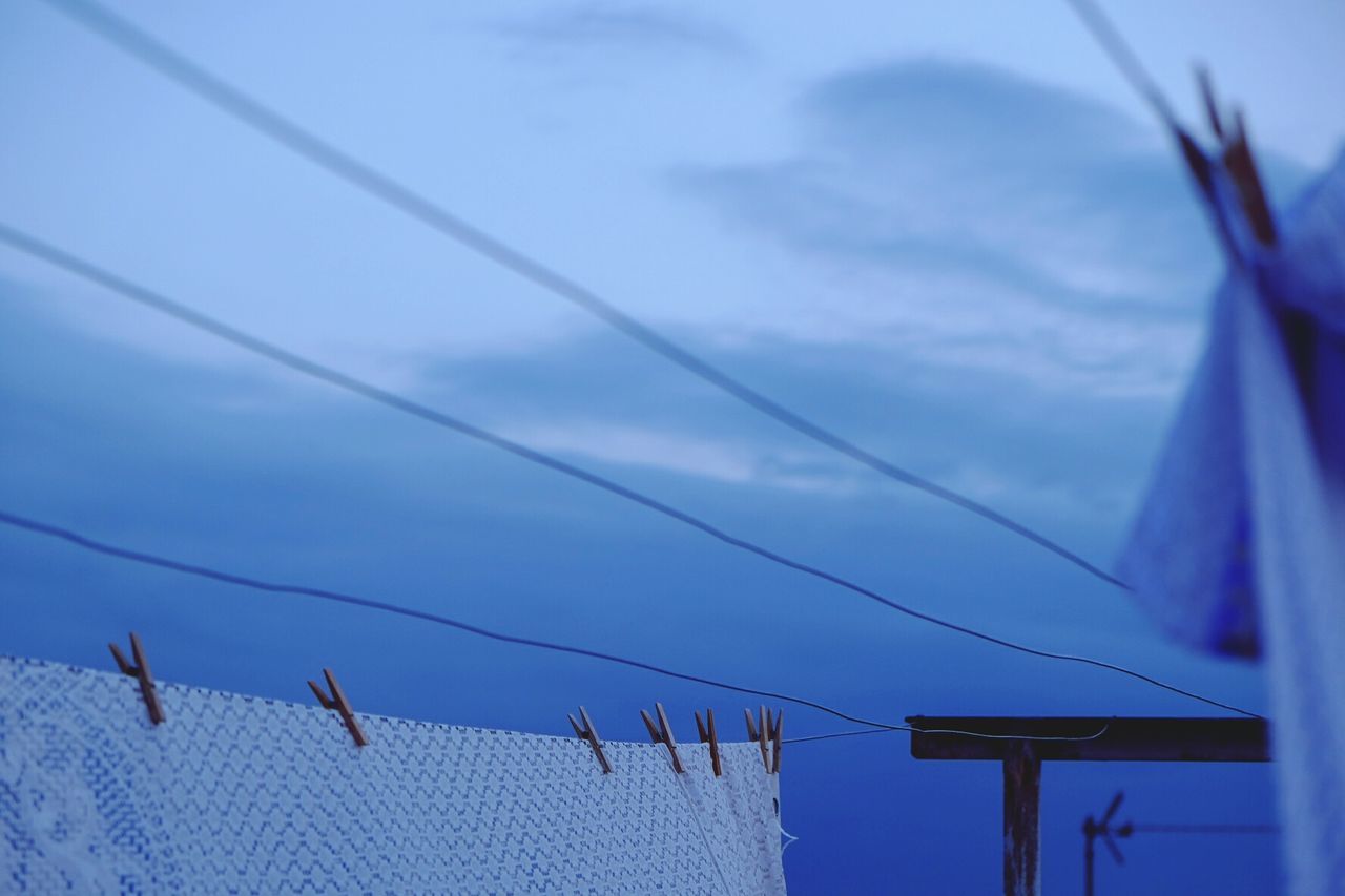 Close-up of clothes drying against the blue sky